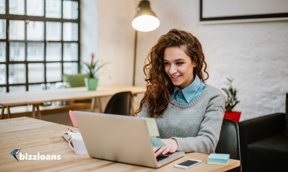 young woman checking credit score on laptop