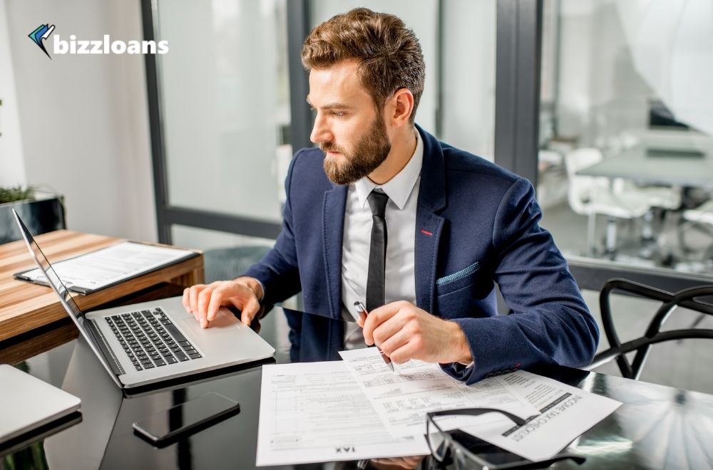 business owner managing his cashflow while looking at his laptop at the office