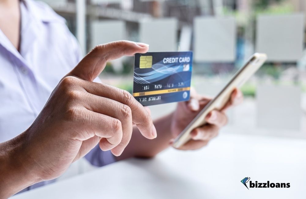 man holding a credit card and smart phone