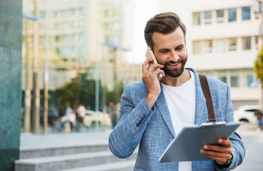 happy business man talking on mobile phone while checking a document