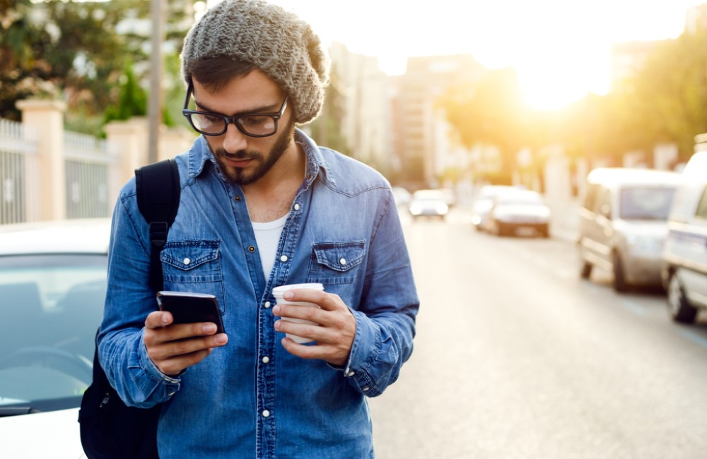 business owner comparing business loans on smart phone while walking