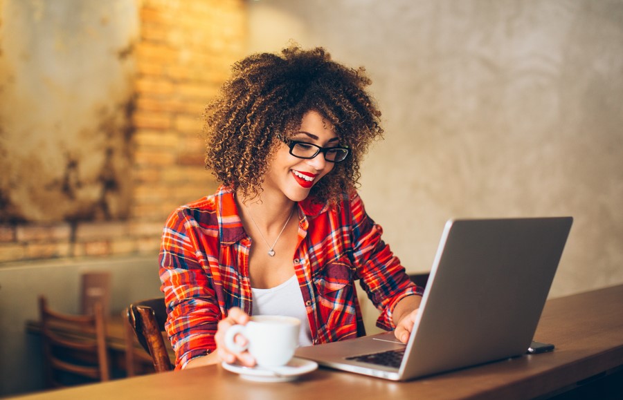 happy business woman comparing business loans on laptop