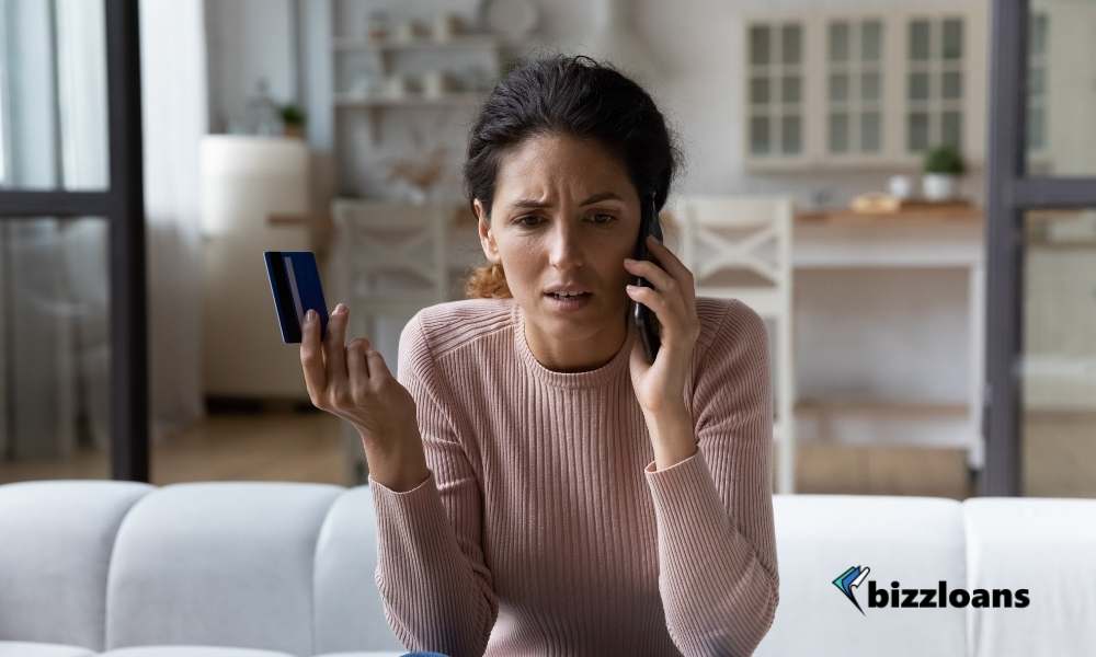 woman with bad credit talking on the phone while holding a credit card