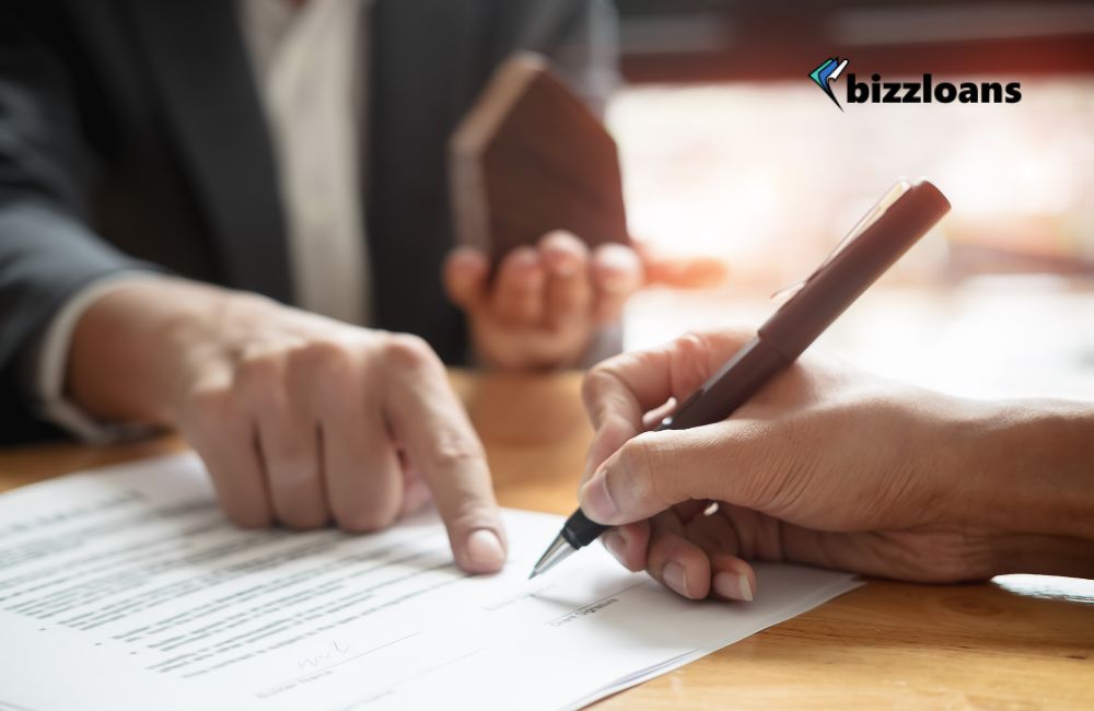 business loan agent showing client where to sign as personal guarantee