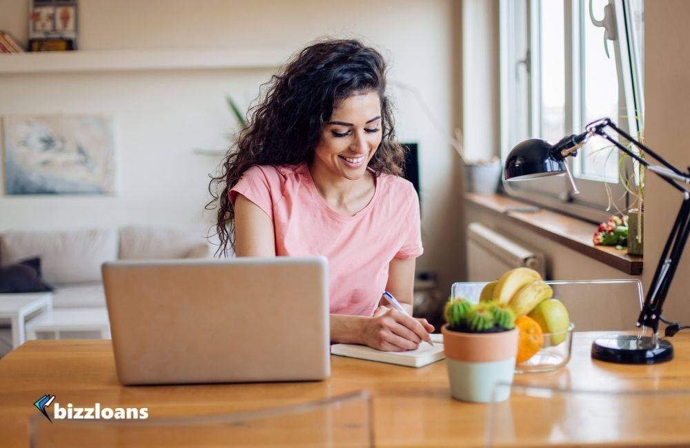 happy business woman applying for a small business loan online at home