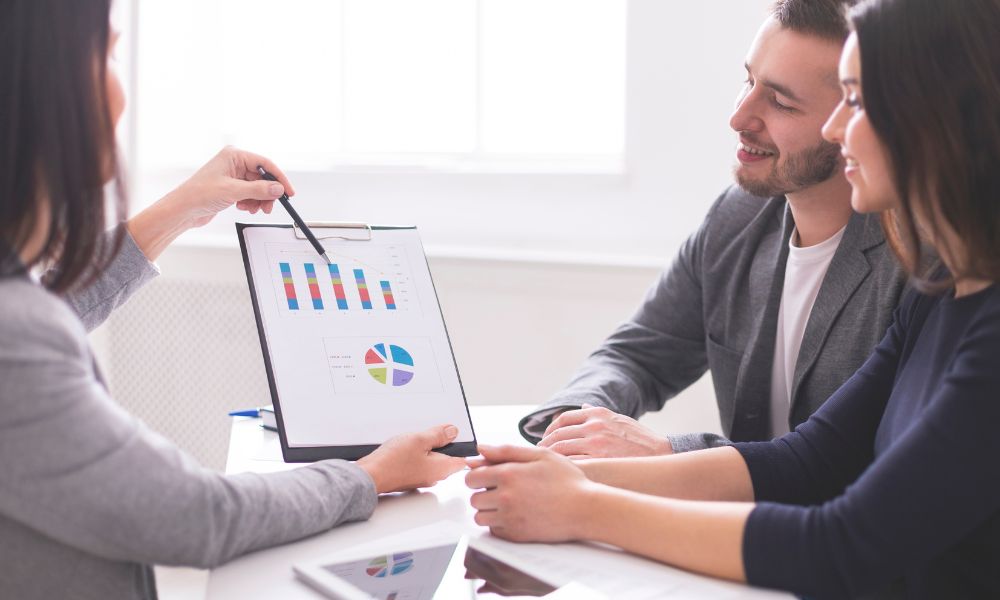 Financial advisor showing payments plan to two business owners